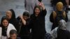 FILE - A woman flashes a victory sign as she walks around in the old main bazaar of Tehran, Oct. 1, 2022. 