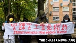 示威者在中国驻曼彻斯特领事馆外手持北京四通桥悬挂反习标语的横幅举行抗议。中国驻曼彻斯特领事馆工作人员随后出来把示威者扯进领事馆内进行殴打。（2022年10月16日）