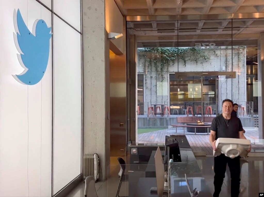 马斯克搬着一个洗手池盆进入在旧金山的推特总部。（2022年10月26日）(photo:VOA)
