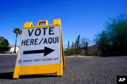 FILE - A sign marks the entrance to a voting precinct on the first day of early voting in the general election in Phoenix, Oct. 12, 2022.