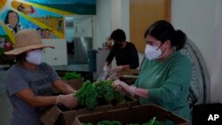 From left, Polly Sang, Patty Apple and Jen Franco, sort and clean vegetables for donation at Food Shift, a nonprofit organization that collects unwanted groceries and distributes them to the needy, Sept. 13, 2022, in Alameda, Calif.