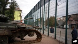 People look at a display of destroyed Russian military vehicles during the Defender of Ukraine Day in Kryvyi Rih, Ukraine, Oct. 14, 2022. 