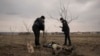 Офицеры украинской полиции идентифицируют останки украинского военнослужащего, убитого, когда это село было оккупировано российской армией. Украина. 5 апреля 2022 г.