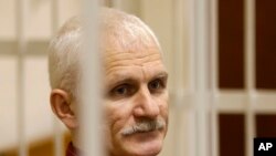 FILE - Ales Bialiatski, the head of Belarusian Vyasna rights group, stands in a defendants' cage during a court session in Minsk, Belarus, on Wednesday, Nov. 2, 2011.