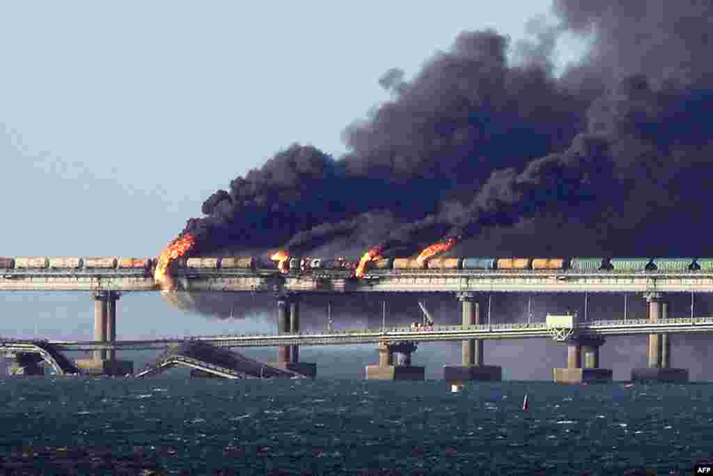 Black smoke billows from a fire on the Kerch bridge that links Crimea to Russia, after a truck exploded, near Kerch, Oct. 8, 2022. 