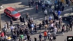 In this frame grab from video taken by an individual not employed by the Associated Press and obtained by the AP outside Iran shows people blocking an intersection during ongoing anti-government protests, in Tehran, Iran, Oct. 26, 2022. 