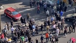 In this frame grab from video taken by an individual not employed by the Associated Press and obtained by the AP outside Iran shows people blocking an intersection during ongoing anti-government protests, in Tehran, Iran, Oct. 26, 2022. 