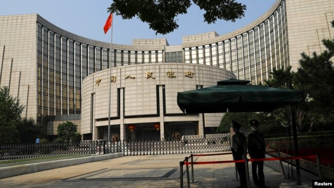 FILE - Police stand guard in front of the headquarters of the People's Bank of China, the country's central bank, in Beijing, Sept. 30, 2022.