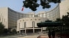 Paramilitary police officers stand guard in front of the headquarters of the People's Bank of China, the central bank (PBOC), in Beijing, Sept. 30, 2022. 