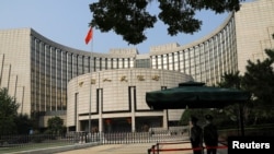 Paramilitary police officers stand guard in front of the headquarters of the People's Bank of China, the central bank (PBOC), in Beijing, Sept. 30, 2022. 