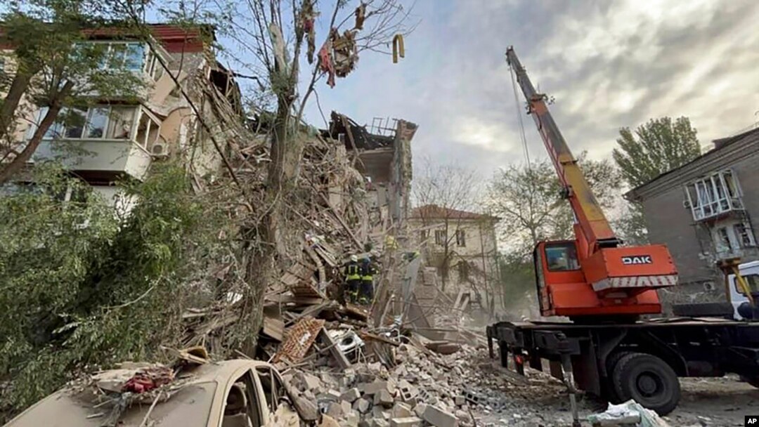 In this photo provided by the Ukrainian Emergency Service, rescuers work at the scene of a building damaged by shelling in Zaporizhzhia, Ukraine, Oct. 6, 2022.