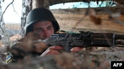 A soldier of the National Guard of Ukraine takes position in a trench in the northern occupied territories of Kharkiv region on Oct. 21, 2022.