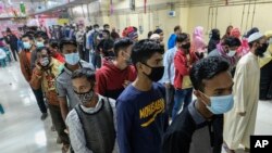 বাংলাদেশের ঢাকায়, করোনভাইরাস সংক্রমণের বৃদ্ধির মধ্যে লোকেরা কোভিড-১৯ এর টিকা গ্রহণের জন্য লাইনে দাঁড়িয়েছে। ৩০ জানুয়ারী, ২০২২। (ফাইল ছবি) 