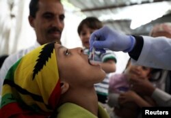 FILE - A girl receives a cholera vaccination during a house-to-house immunization campaign in Sanaa, Yemen, April 24, 2019.