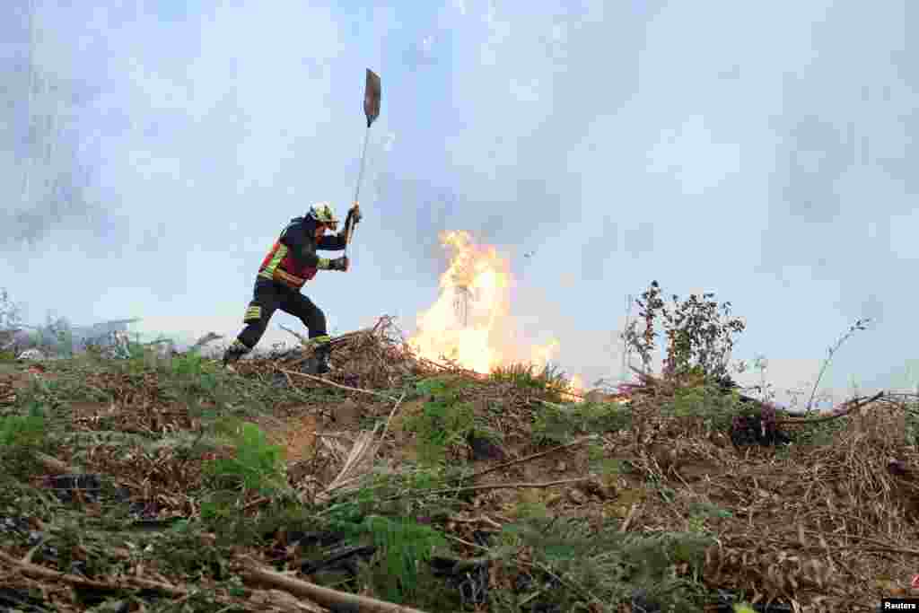 A firefighter battles a forest blaze in Sopela, Spain.