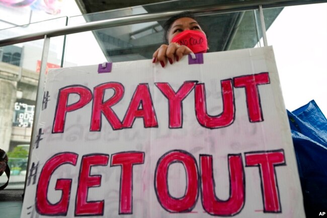 An anti-government protester holds a sign in Bangkok, Thailand, Sept. 30, 2022.