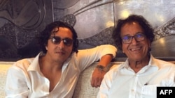 FILE - This handout photo released by the Almadi family, shows Ibrahim Almadi (L), posing for a picture with his father, Saad, at a vacation resort in Florida on June 20, 2021.