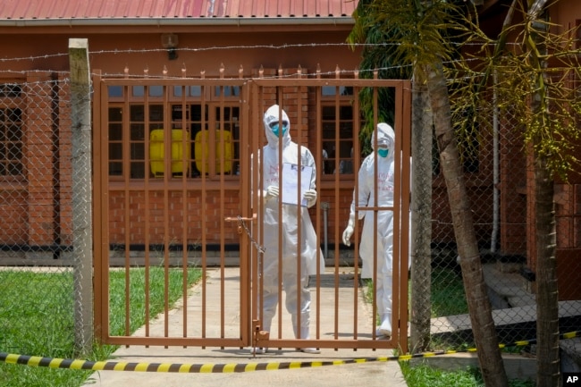 Doctors wearing protective equipment are seen after visiting a patient who was in contact with an Ebola victim, in the isolation section of Entebbe Regional Referral Hospital in Entebbe, Uganda Thursday, Oct. 20, 2022. (AP Photo/Hajarah Nalwadda)