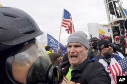 FILE - In this Jan. 6, 2021, image from video, Alan William Byerly, center, is seen attacking an Associated Press photographer during a riot at the U.S. Capitol in Washington.