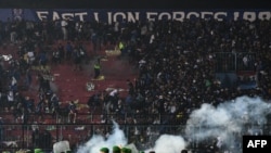 Petugas keamanan (bawah) mengamankan lapangan dengan menggunakan gas air mata usai pertandingan sepak bola antara Arema FC dan Persebaya Surabaya di Stadion Kanjuruhan, Malang, Jawa Timur. (Foto: AFP)