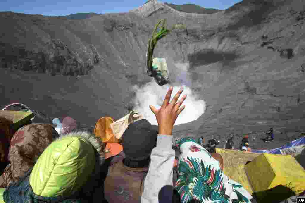 Suku Tengger yang beragama Hindu melemparkan sesaji ke kawah aktif Gunung Bromo di Jawa Timur selama upacara tahunan Kasada.