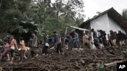 Warga berjalan di kawasan yang terkena longsor di Banjarnegara, Jawa Tengah, Indonesia, Minggu, 19 Juni 2016.