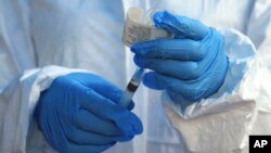 Un travailleur de la santé de l'OMS se prépare à administrer un vaccin contre le virus Ebola à un patient à Mangina, en République démocratique du Congo, le 8 août 2018.