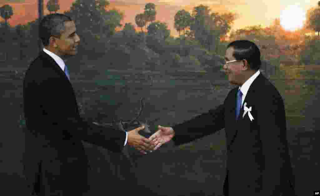U.S. President Barack Obama, left, is greeted by Cambodia's Prime Minister Hun Sen before the ASEAN-U.S. leaders meeting in Phnom Penh, Cambodia, Monday, Nov. 19, 2012. (AP Photo/Vincent Thian)