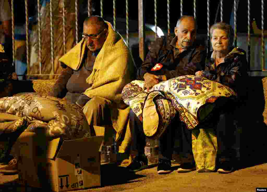 People cover themselves with blankets as they prepare to spend the night in the open following an earthquake in Amatrice, central Italy, Aug. 24, 2016. 