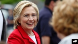 FILE - Democratic presidential candidate Hillary Clinton greets a spectator at a Fourth of July parade in Gorham, New Hampshire, July 4, 2015.