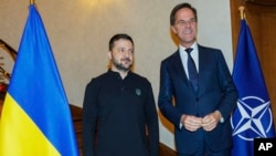 NATO Secretary General Mark Rutte, right, greets Ukraine's President Volodymyr Zelenskyy prior to a meeting in Brussels, Dec. 18, 2024. 