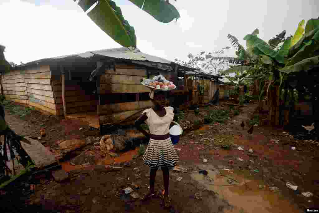 가나의 한 마을에서 소녀가 달걀이 든 소쿠리를 머리에 이고 이동하고 있다.