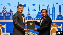 Ukraine's Foreign Minister Dmytro Kuleba (L) poses with Cambodia's Foreign Minister Prak Sokhonn (R) during the signing ceremony of the Instrument of Accession to the Treaty of Amity and Cooperation in Southeast Asia (TAC) by Ukraine, in Phnom Penh on November 10, 2022.