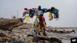 The environmental activist Modou Fall, who many simply call "Plastic Man," poses for a photo at the Yarakh Beach littered by trash and plastics in Dakar, Senegal, Nov. 8, 2022. 