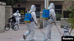 身穿防護服的防疫人員在北京一個被封的居民區噴灑消毒藥水。（2022年11月9日）