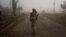 A Ukrainian serviceman stands on a street in a village near the newly recaptured city of Snihurivka, in Mykolaiv region, Ukraine Nov. 10, 2022.