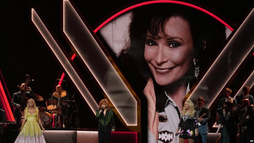 Carrie Underwood, de izquierda a derecha, Reba McEntire y Miranda Lambert rinden homenaje a la fallecida cantante Loretta Lynn, representada en la pantalla, durante la 56.ª Entrega Anual de los Premios CMA el miércoles 9 de noviembre de 2022 en el Bridgestone Arena de Nashville, Tennessee. ( Foto AP/Mark Humphrey)