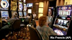 FILE - Patrons at the San Manuel Indian Bingo & Casino play slot machines June 8, 2006, on the San Manuel Indian Reservation, Calif.