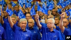 លោក Ahmad Zahid Hamidi ប្រធាន​សម្ពន្ធភាព​ចម្រុះ​នៃ​គណបក្ស UMNO និង​គណបក្ស Barisan National (ឆ្វេង) និង​លោក Ismail Sabri Yaakob នាយករដ្ឋមន្ត្រី​នៃ​រដ្ឋាភិបាល​ចាំផ្ទះ (ស្តាំ) បក់​ទង់ជាតិ​ម៉ាឡេស៊ី នៅ​ទីក្រុង​គូឡាឡាំពួ កាល​ពី​ថ្ងៃ​ទី​១ ខែ​វិច្ឆិកា ឆ្នាំ​២០២២។