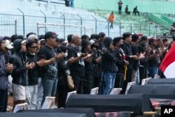 Para pengunjuk rasa berdoa untuk para korban dalam rangka peringatan 40 hari tragedi sepakbola di stadion Kanjuruhan, Malang, Jawa Timur, Kamis, 10 November 2022. (AP/Rizki Dwi Putra)