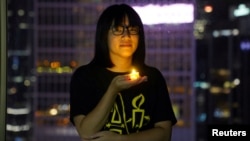 FILE - Hong Kong lawyer Chow Hang-tung poses with a candle ahead of the 32nd anniversary of the crackdown on pro-democracy demonstrators at Beijing's Tiananmen Square in 1989, in Hong Kong, June 3, 2021.