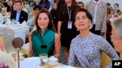 မလေးရှားမင်းသမီး Michelle Yeoh (ဝဲ) နှင့် ဒေါ်အောင်ဆန်းစုကြည်တို့အား စုဖောင်ဒေးရှင်းတည်ထောင်ခြင်းနဲ့ အပြည်ပြည်ဆိုင်ရာ မီဒီယာ အကြိုဖွင့်ပွဲမှာ အတူတွေ့ရစဉ်။ (မတ်လ ၉၊ ၂၀၁၄)