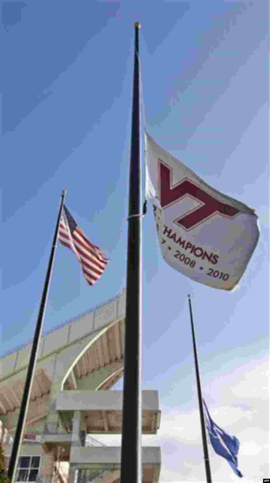 A Virginia Tech flag and the state of Virginia flag fly at half-staff in front of Lane Stadium on the campus of Virginia Tech in Blacksburg, Va., Friday, Dec. 9, 2011. A Virginia Tech police officer was shot and killed on campus Thursday. (AP Photo/Steve