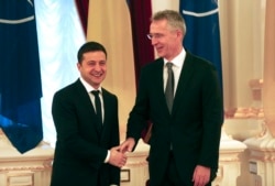 FILE - Ukrainian President Volodymyr Zelenskiy, left, welcomes NATO Secretary-General Jens Stoltenberg during their meeting in Kyiv, Ukraine, Oct. 31, 2019.