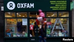 A pedestrian walks past a branch of Oxfam, in London, Feb. 12, 2018. 