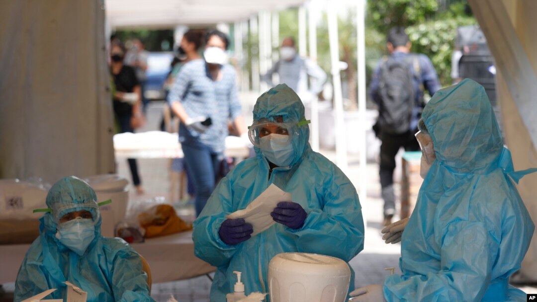 Health workers get ready at a COVID-19 testing center in New Delhi, India, April 27, 2020. India’s main medical research organization has cancelled orders to procure rapid antibody test kits from two Chinese companies. 