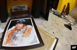A broken portrait of former Bolivia's President Evo Morales is on the floor of his private home in Cochabamba, Bolivia, after hooded opponents broke into the residence on Nov. 10, 2019.