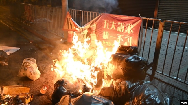 2019年11月18日香港抗议者试图以燃烧垃圾阻挡警察。（美国之音郁岗拍摄）