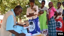 A health worker records information from patient's health passport in Balaka district in southern Malawi. Feared to be carriers of the coronavirus, some medical workers in Malawi have been increasingly shunned. (Lameck Masina/VOA)