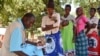Un agent de santé enregistre les informations du passeport de santé du patient dans le district de Balaka, dans le sud du Malawi. (Lameck Masina / VOA)